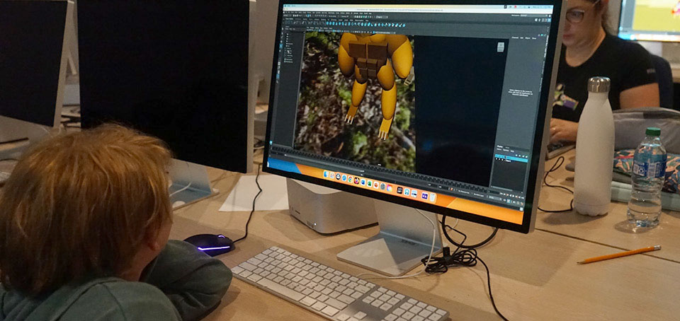 Student creating an image on a computer screen in a computer room.