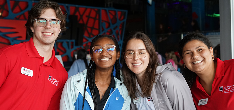 Four employee students at the Georgia Center smiling